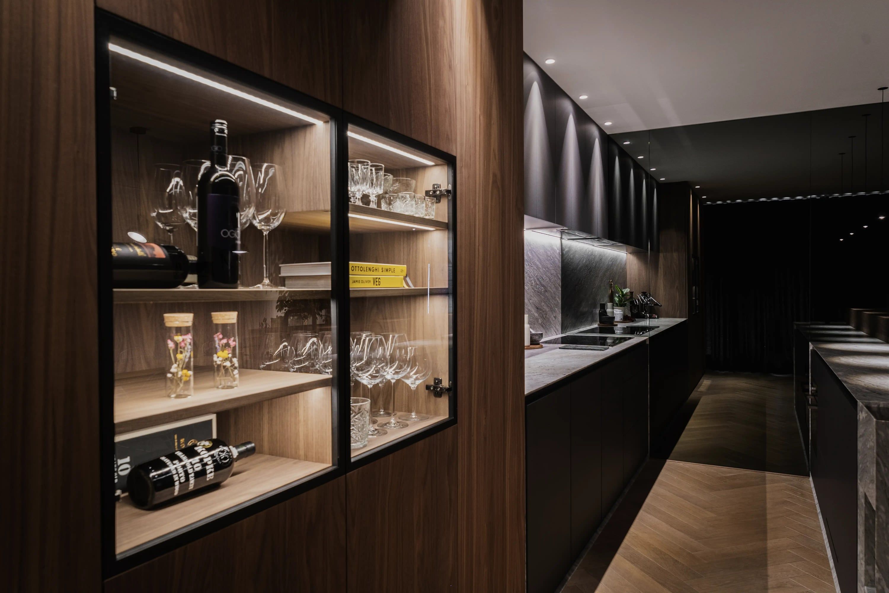 Vitrine in de houten wand met zicht langs de lange keuken