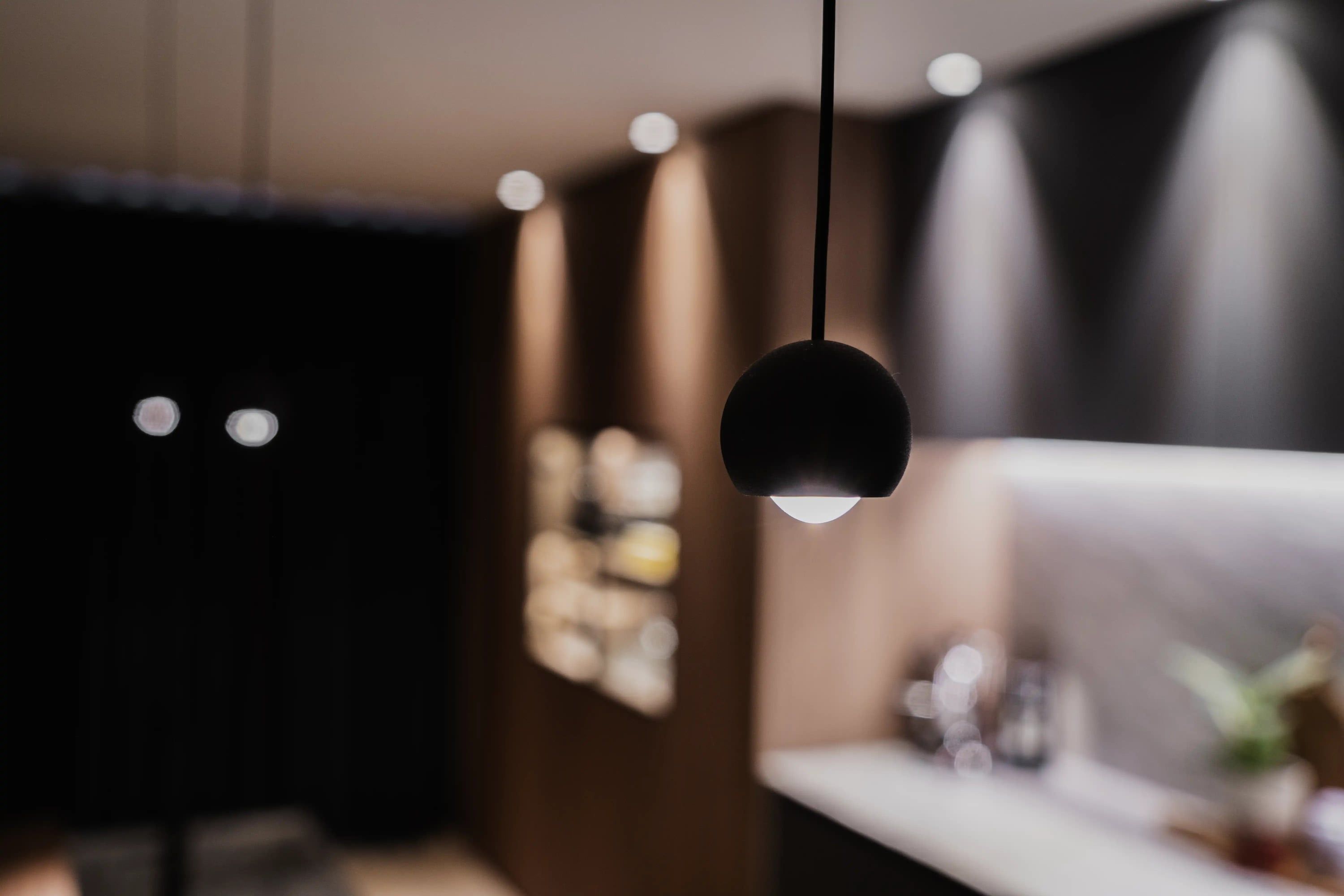 Zwarte bolvormige hanglamp voor de onscherpe keuken